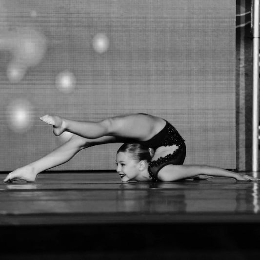 Skilled acro dancer striking a graceful pose, showcasing flexibility and balance for the Charleston Dance Center.